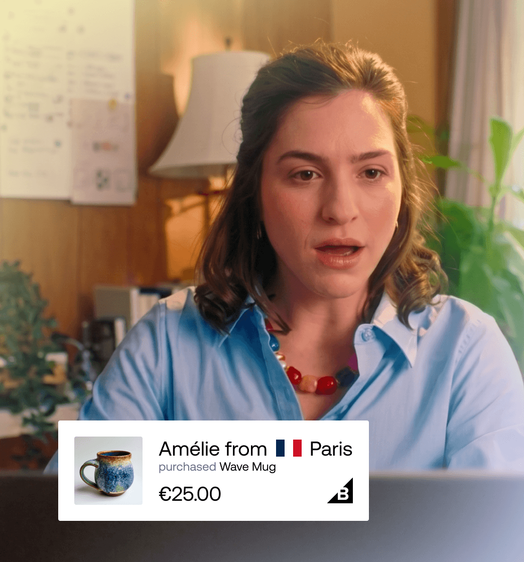 Kvinde kigger på skærm med live social proof-badge, der viser, at Amélie fra Paris har købt et Wave Mug for 25 €